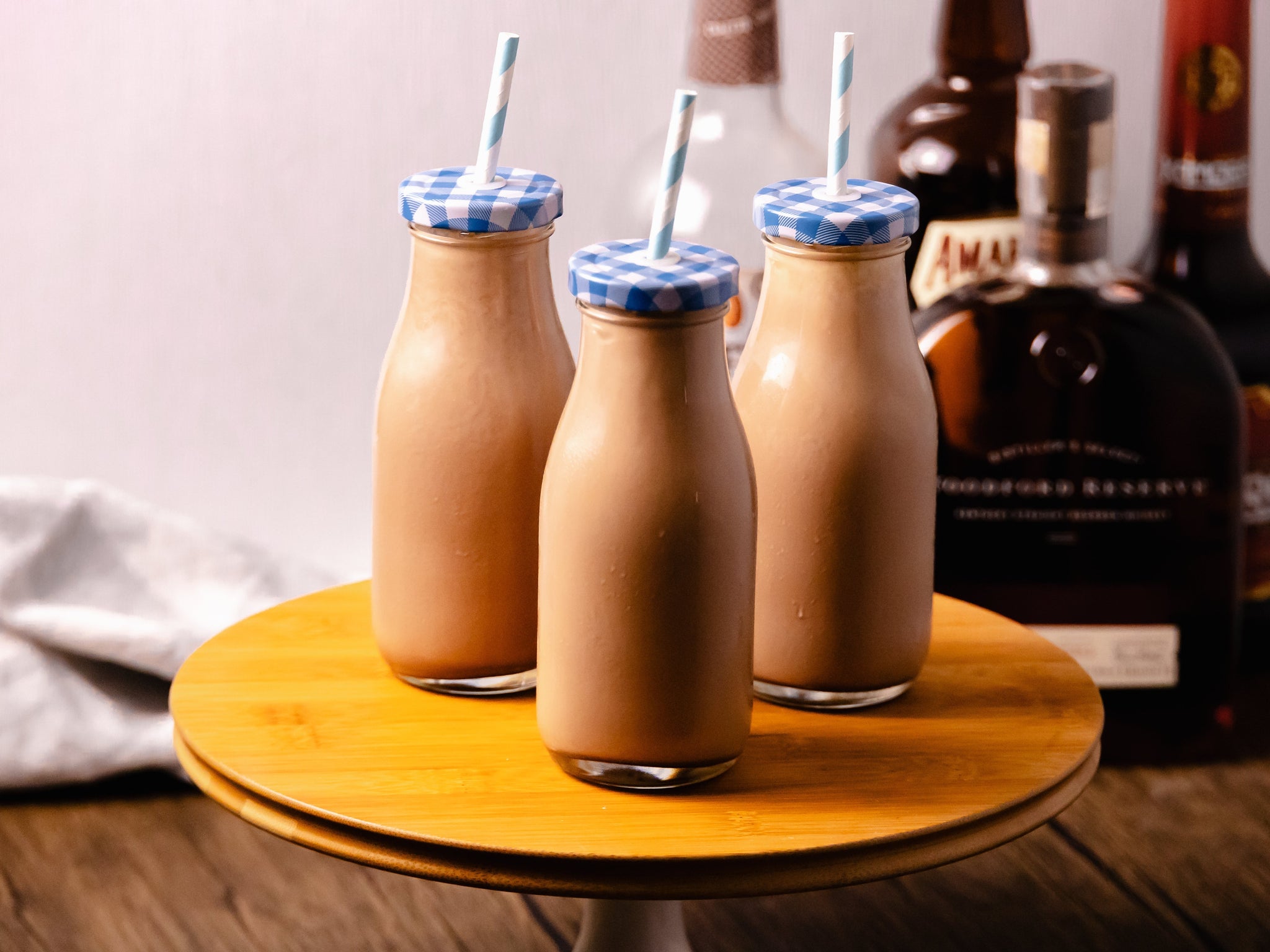 chocolate milk cocktails with liquor bottles in background