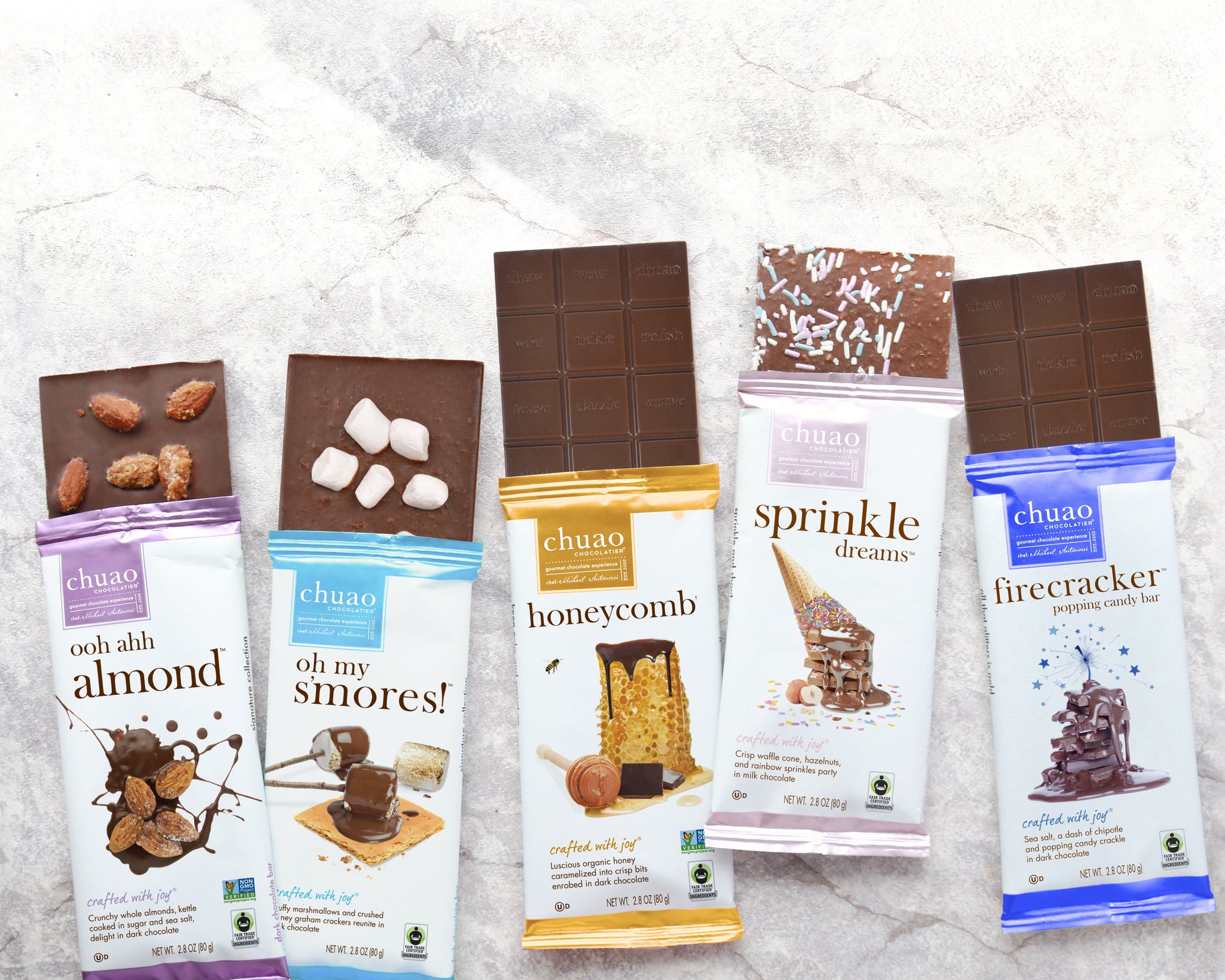 5 chocolate bars laying with labels up, spread evenly over a marble countertop.