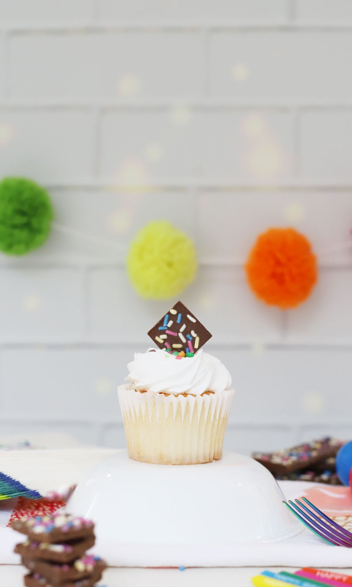 vanilla cupcake with sprinkle dreams chocolate square as garnish