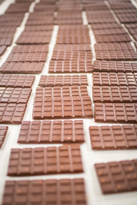 a conveyor belt full of unwrapped chocolate bars