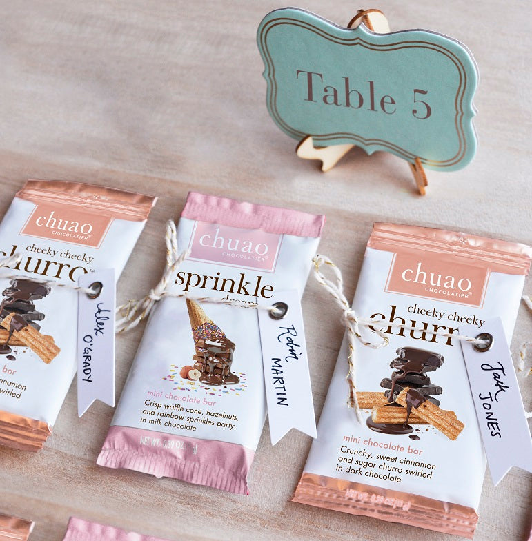 Three mini chocolate bars with name tags by a table sign