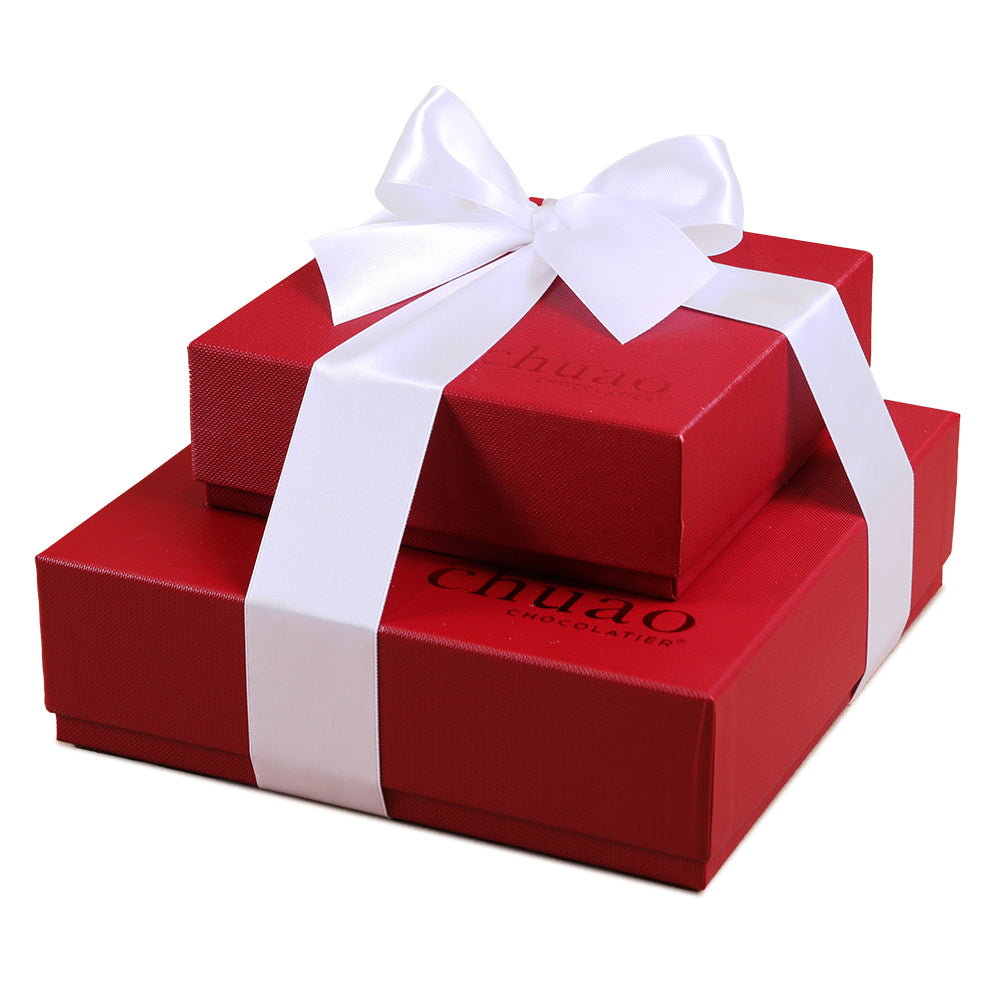 two red chuao gift boxes stacked on one another tied with a white ribbon