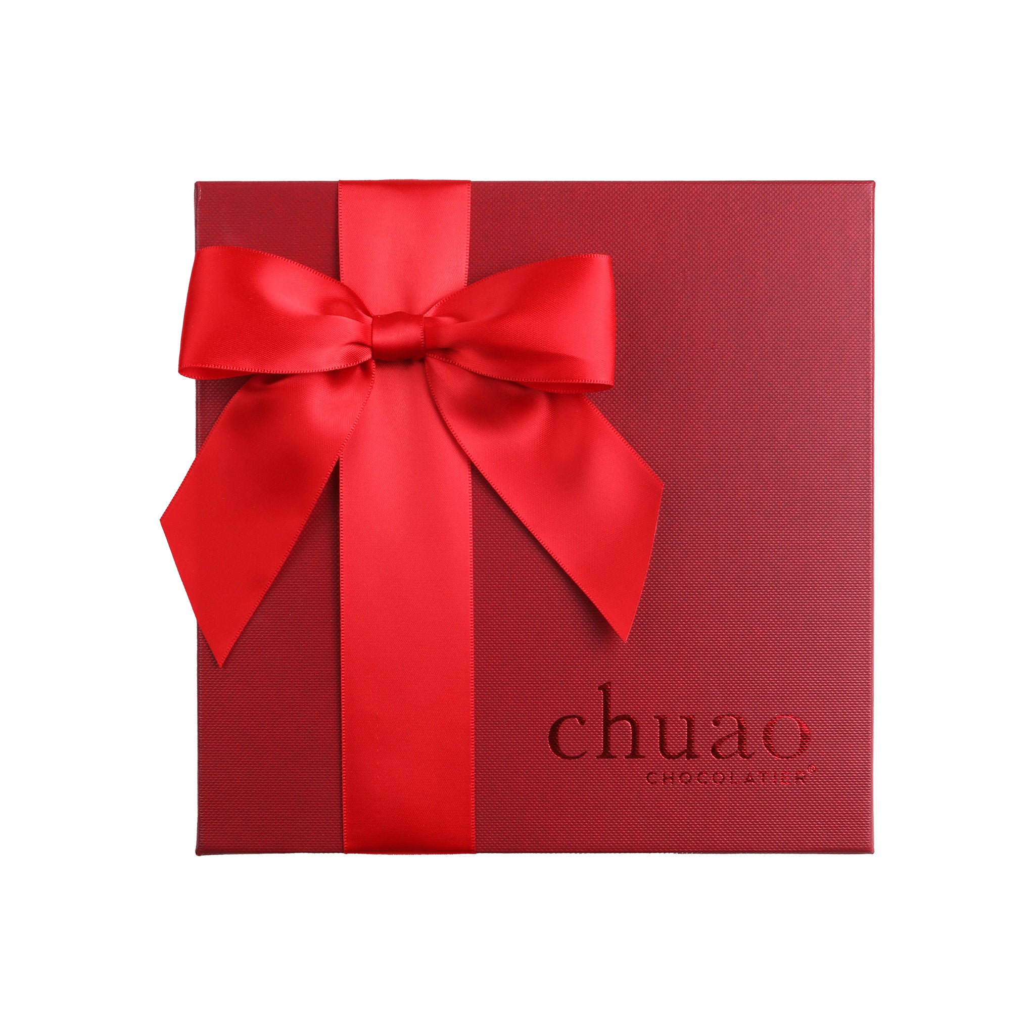 Bright red bow over a deep red gift box engraved with chuao