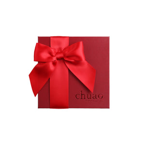 Dark red gift box with bright red bow engraved with chuao
